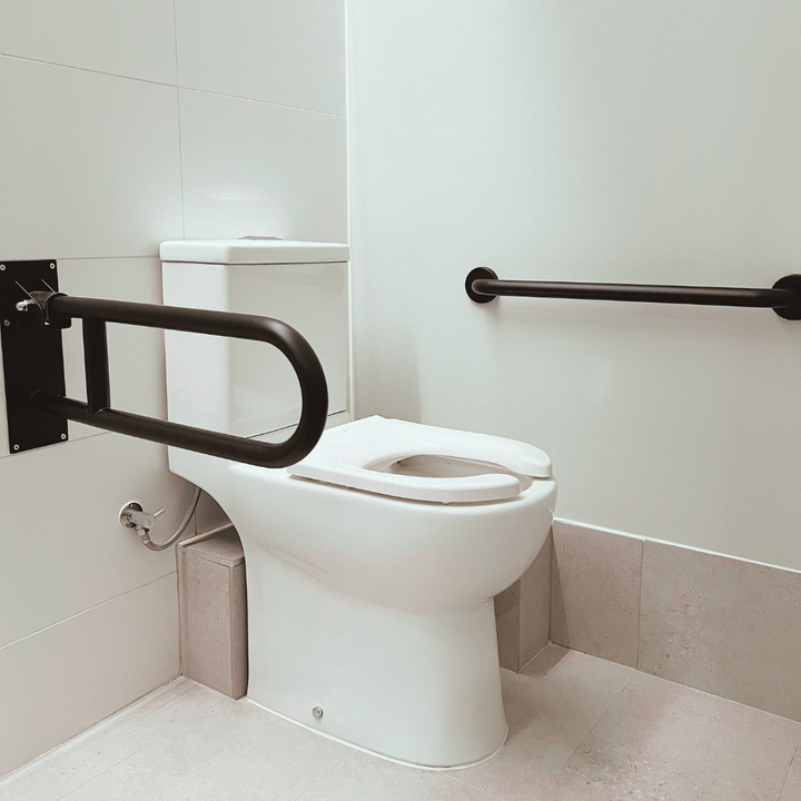 Barra de seguridad Abatible a muro negra instalada en baño