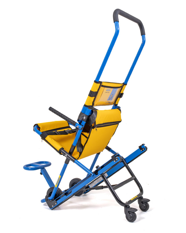 Silla de evacuación Evac+Chair 400H desplegada, vista lateral: respaldo con bolsillo de instrucciones, asiento amarillo, apoyapiés y ruedas traseras.